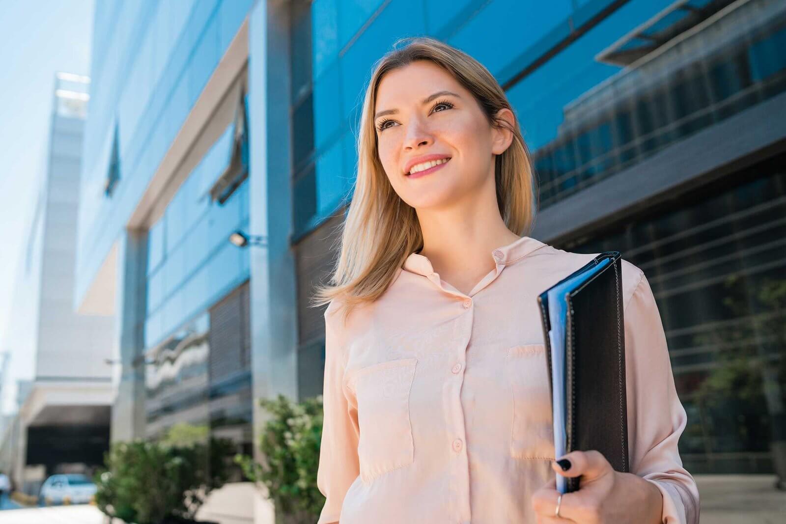 business woman standing outside office buildings cwdby8q