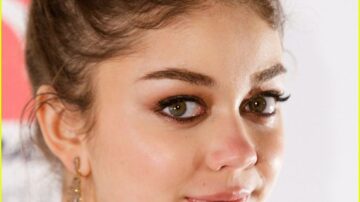 Young woman with brown hair and earrings.